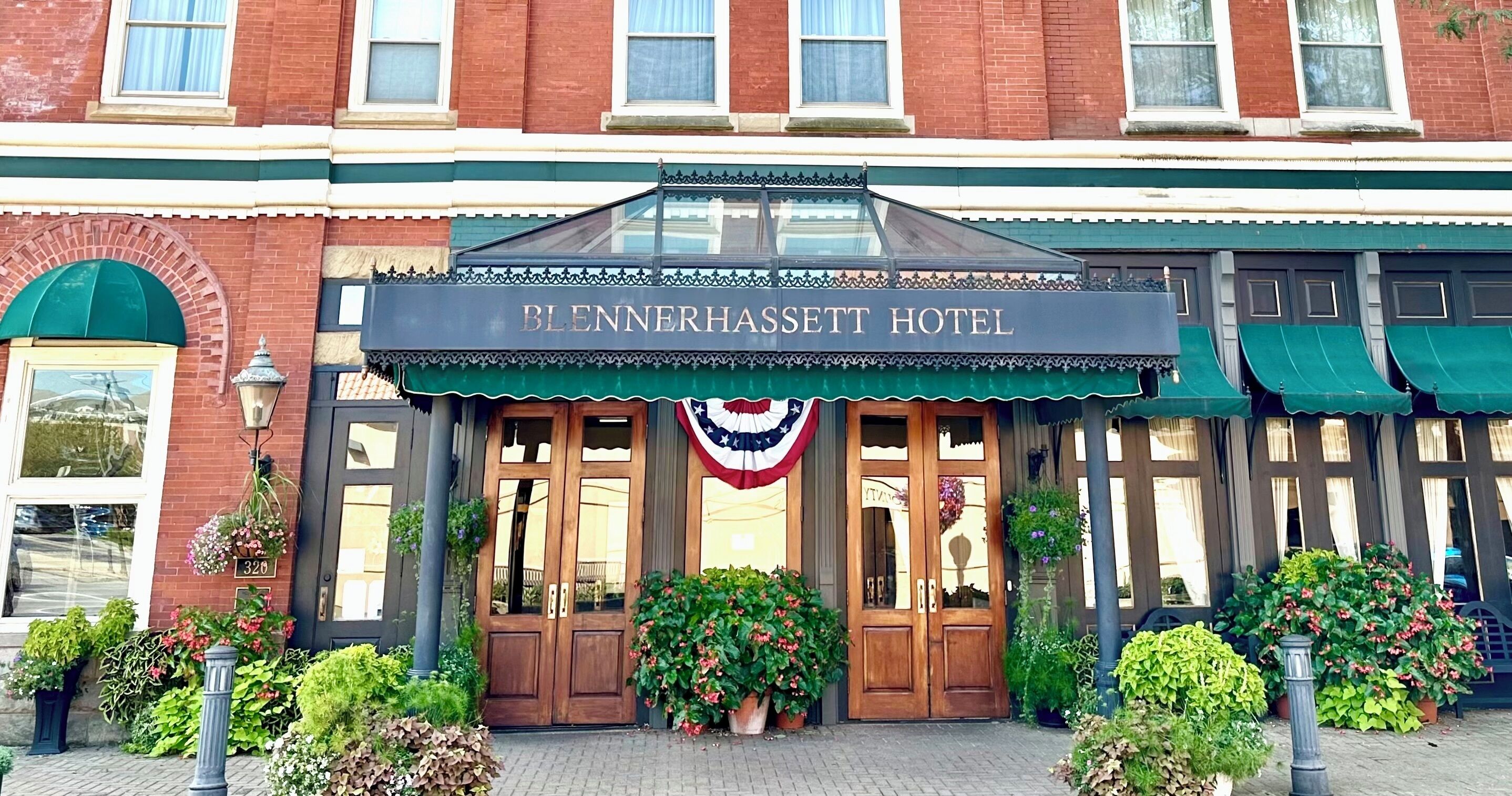 The exterior of the Blennerhassett Hotel with a traditional facade, large wooden doors, and a marquee sign above the entrance.