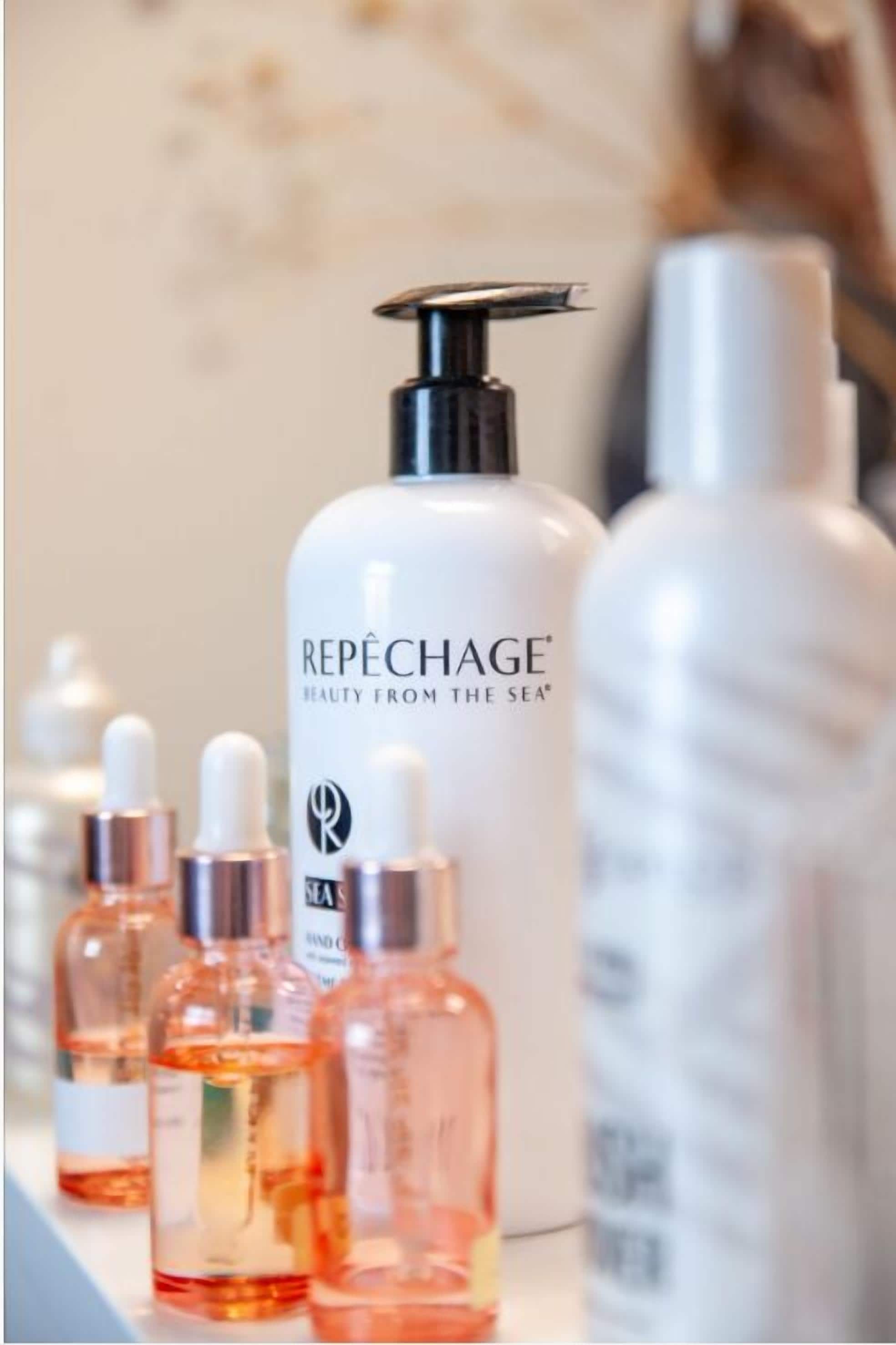 A row of skincare bottles with the label "REPÉCHAGE BEAUTY FROM THE SEA" on a countertop.