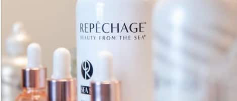 A row of skincare bottles with the label "REPÉCHAGE BEAUTY FROM THE SEA" on a countertop.