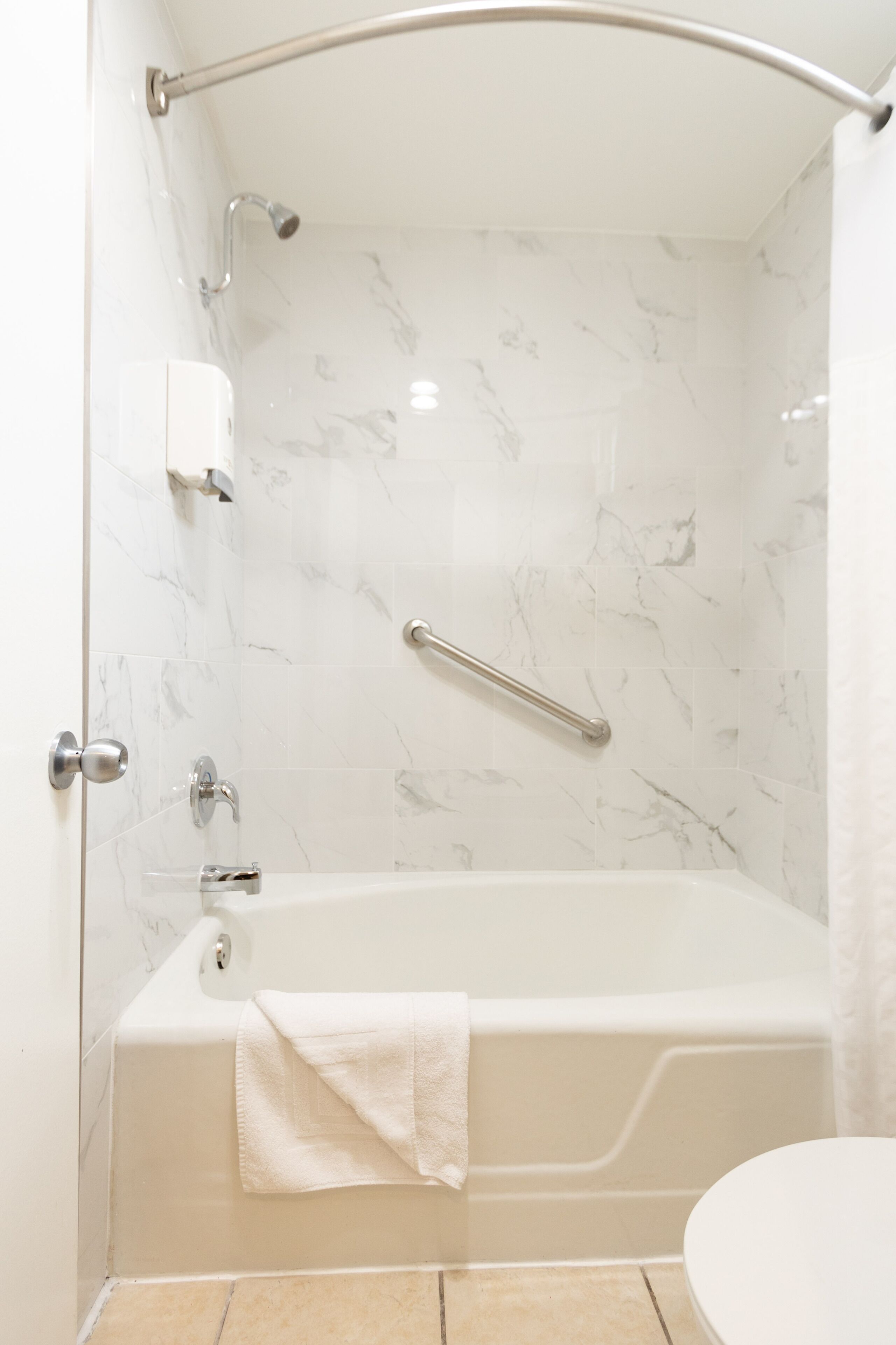 Ein modernes Badezimmer mit Badewanne, Toilette und Duschbereich.