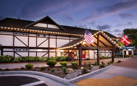 A traditional building with a covered entrance, American and Danish flags, and a sign for "The King Frederik's".