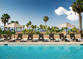 Una piscina al aire libre, sillones reclinables de piscina