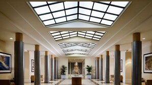Un hall d’entrée spacieux avec un plafond haut, des puits de lumière et un comptoir d’accueil central.