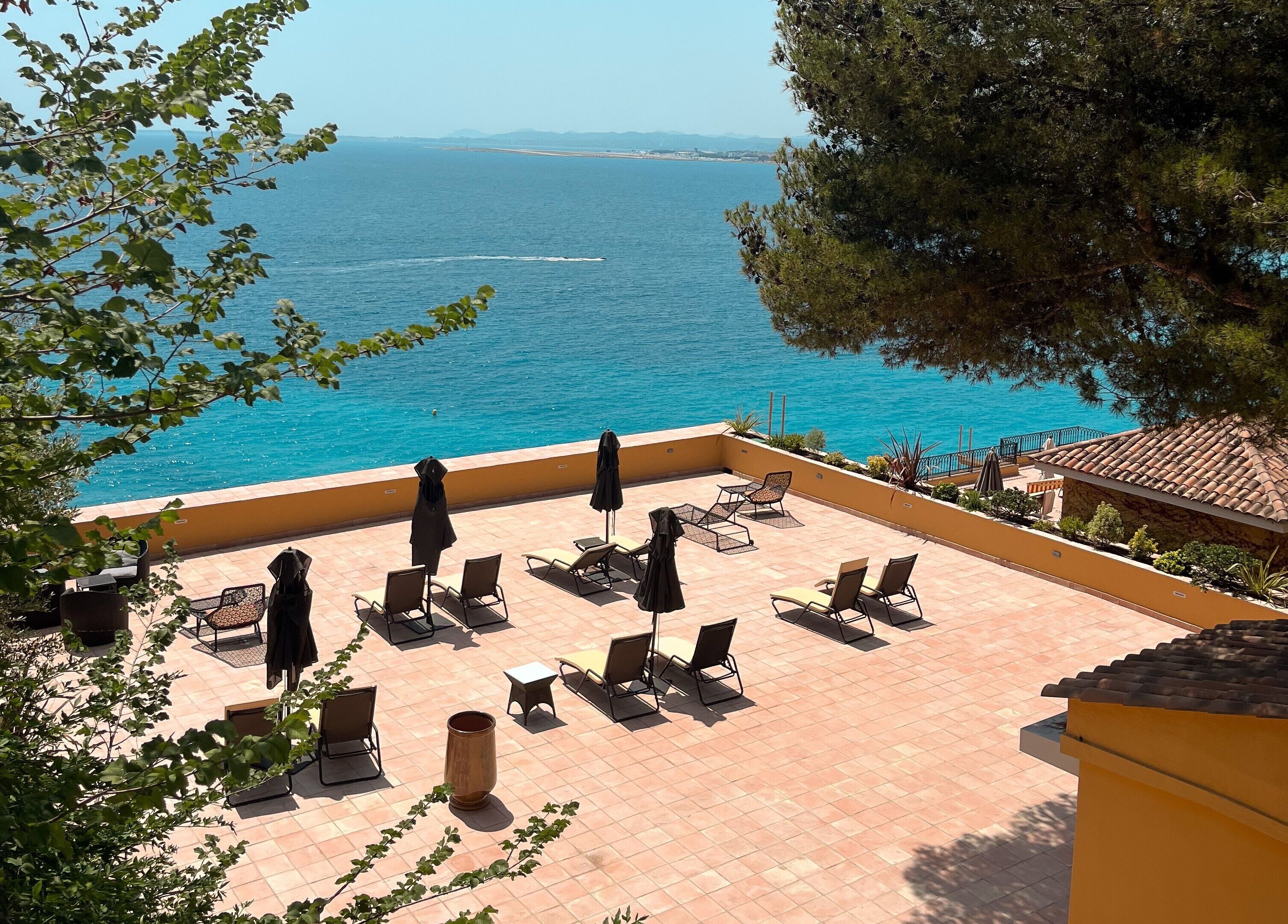 A terrace with outdoor seating and a view of the sea.