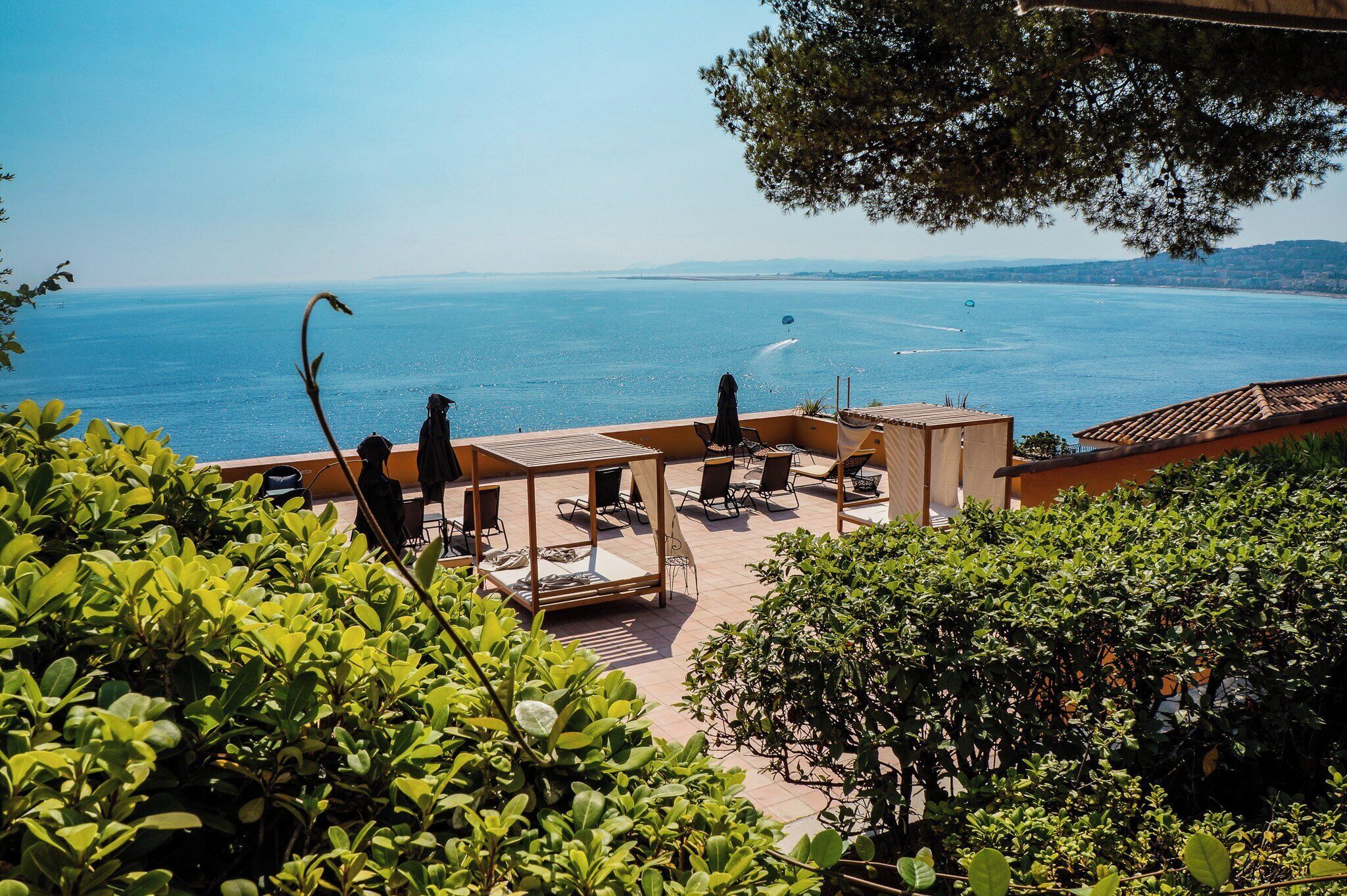 A terrace with outdoor seating overlooking a body of water.