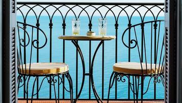 Un balcón con dos sillas y una mesa, con vista a un cuerpo de agua.