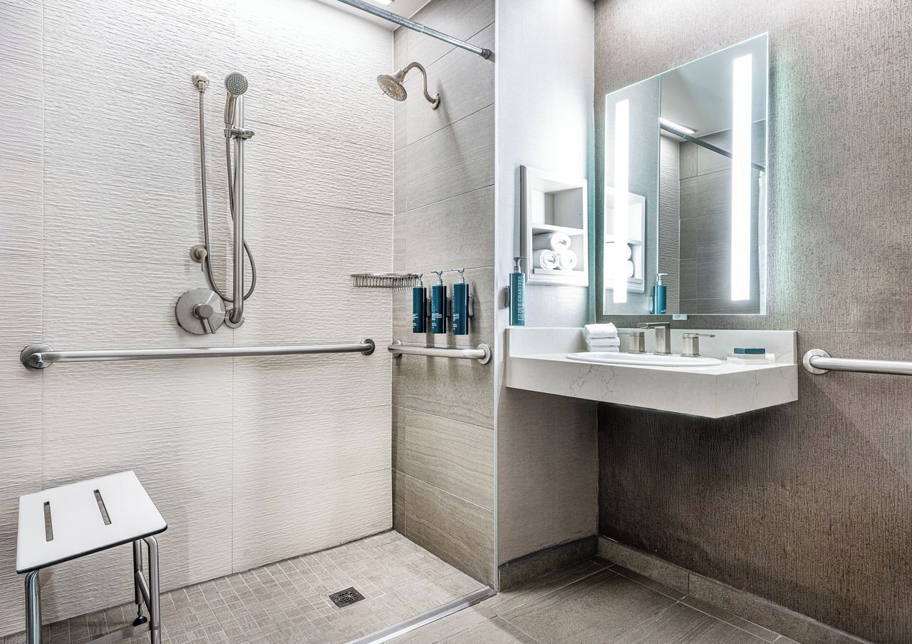 A modern bathroom with a shower, a toilet, and a sink.