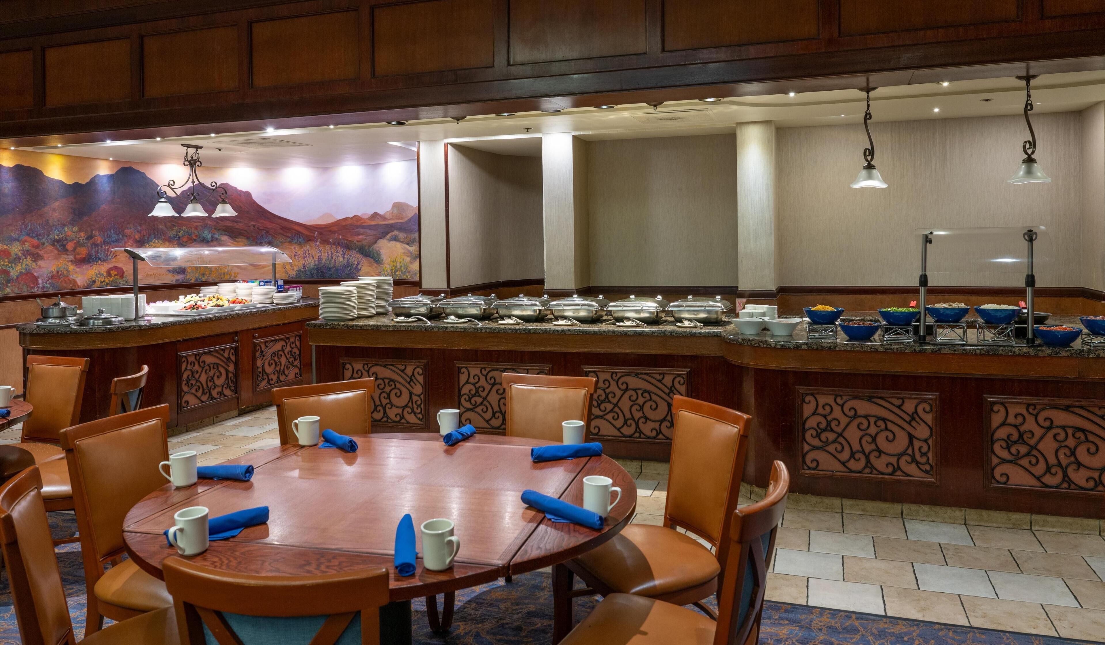Un espace buffet avec un îlot central, entouré de tables et de chaises.