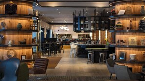 Ein moderner Barbereich mit Holzböden, Barhocker und einer zentralen Bar.