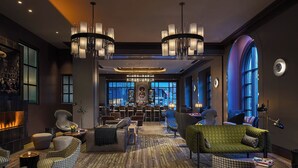 Eine geräumige Lobby mit Kamin, modernen Möbeln und einer großen Chandelüster.