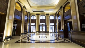 A grand lobby with a marble floor, large arched windows, and a central revolving door. - Claridge Hotel (Buenos Aires)