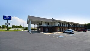 Un motel à deux étages doté d’un parking couvert et de places de stationnement accessibles aux personnes handicapées.