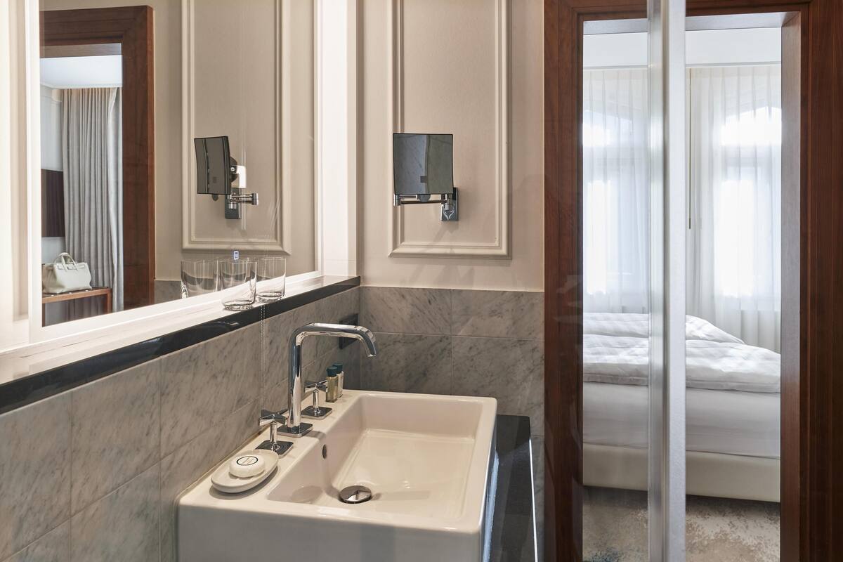 Une salle de bain avec un grand miroir, un lavabo et une douche.