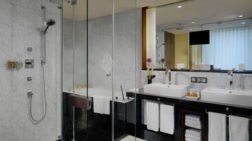 A modern bathroom with a glass-enclosed shower, two sinks, and a large mirror.