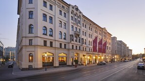 Ein mehrstöckiges Hotel mit Rundbogenfenstern und einer klassizistischen Fassade.