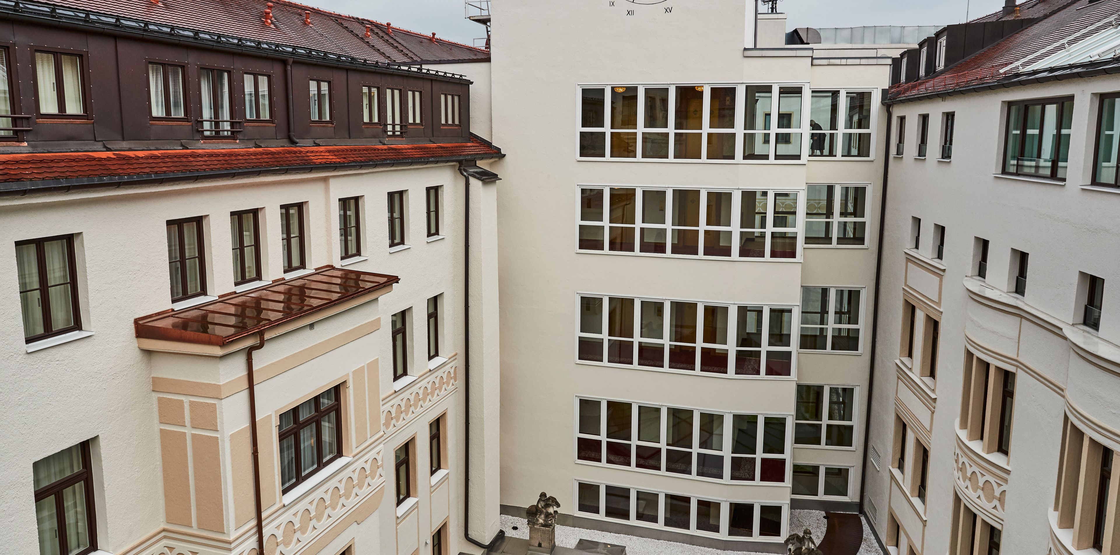 A multi-story building with a central courtyard, featuring a mix of architectural styles and multiple balconies.