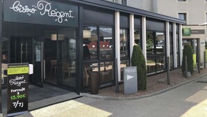 A modern building with a restaurant named 'Bistro Régent' and a sign indicating a hotel. - ibis Styles Clermont Ferrand Le Brezet Aeroport (Clermont-Ferrand)