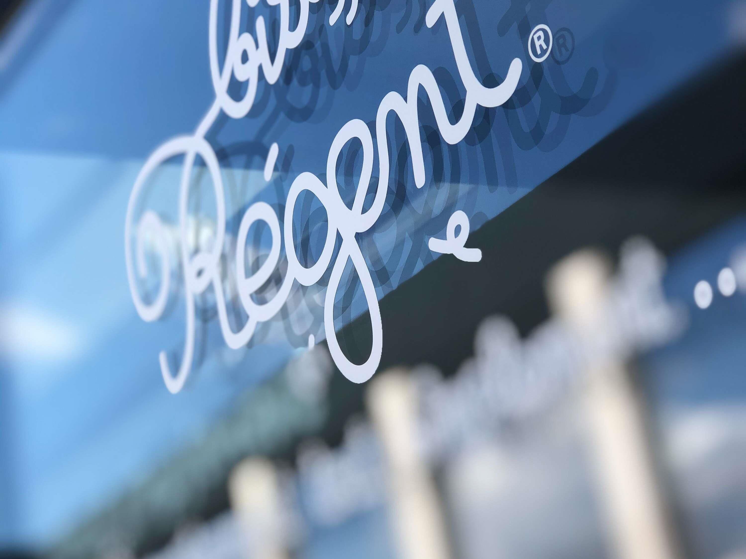 A close-up of a sign with the word "Regent" in cursive script.