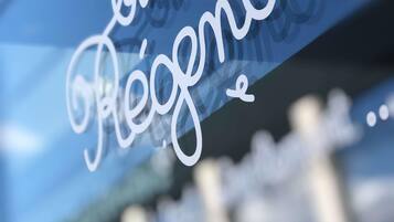A close-up of a sign with the word "Regent" in cursive script.