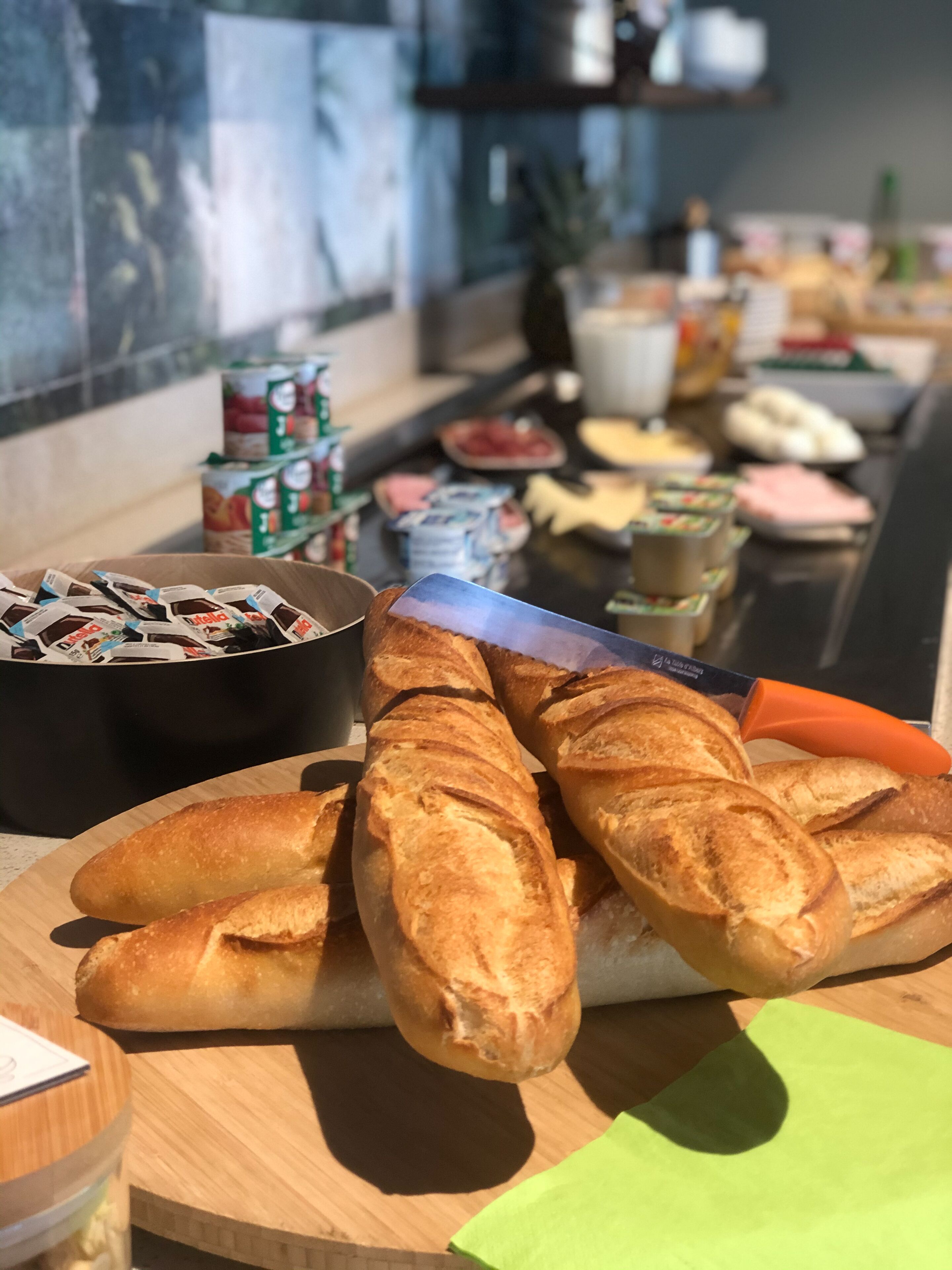 Un bufé de desayuno con pan, frutas y productos lácteos.