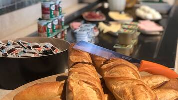 Un bufé de desayuno con pan, frutas y productos lácteos.