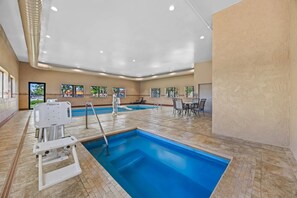 Una piscina techada, sillones reclinables de piscina