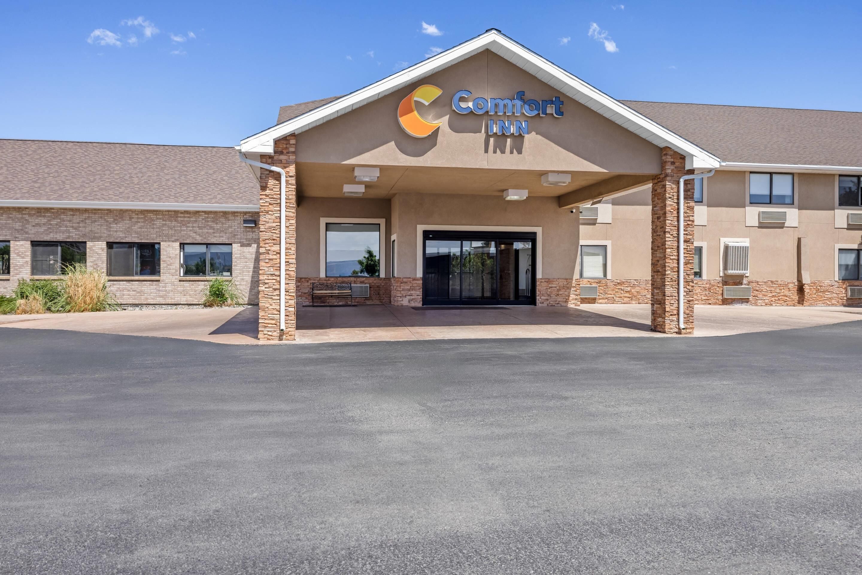 Un hotel Comfort Inn con fachada de ladrillo, ventanas amplias y un acceso cubierto.