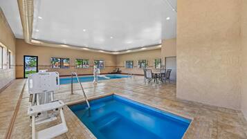 Una piscina techada, sillones reclinables de piscina