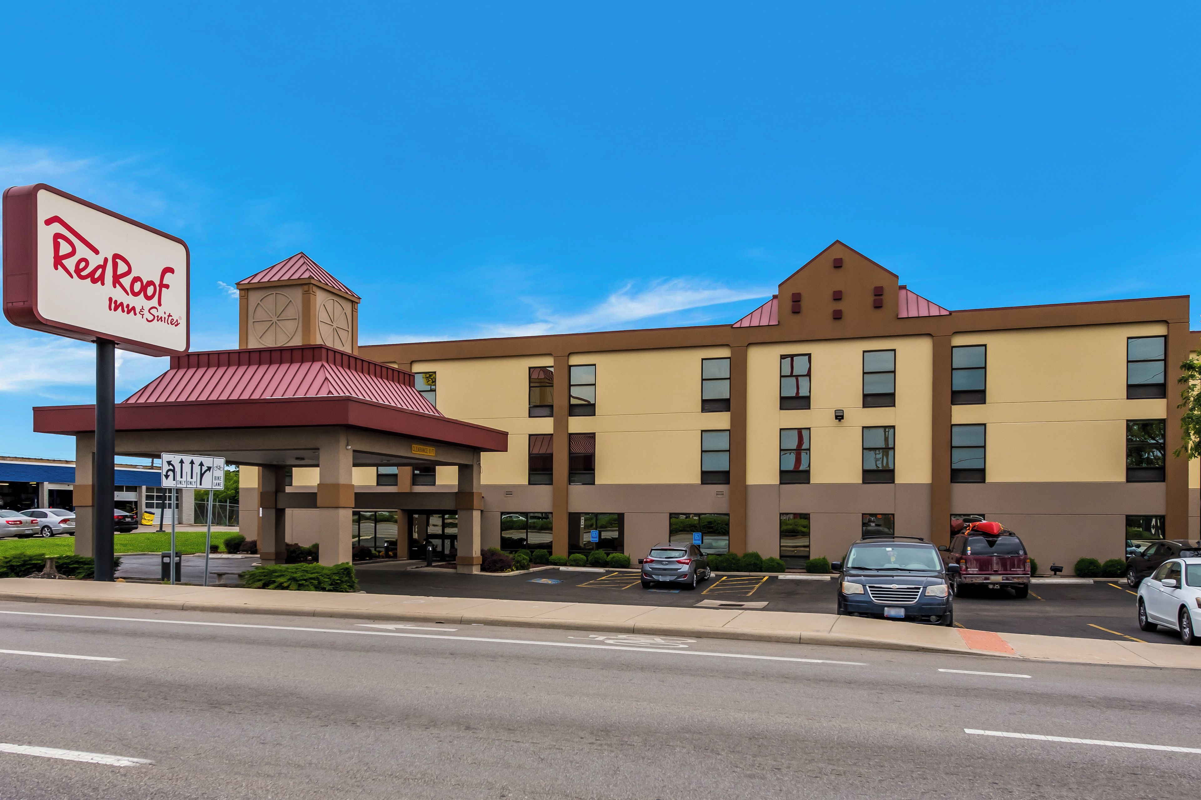 Un bâtiment de la chaîne Red Roof Inn & Suites, avec un ciel bleu dégagé en arrière-plan.