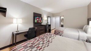 A hotel room with two beds, a desk with a chair, a TV, and a mirror. - Red Roof Inn & Suites Columbus - West Broad (Columbus)