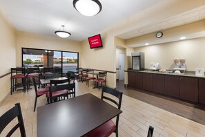 A hotel room with a dining area, a kitchenette, and a large window offering a view of the outside. - Red Roof Inn & Suites Columbus - West Broad (Columbus)