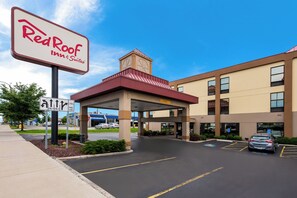 Un hôtel Red Roof Inn & Suites avec un ciel dégagé, un parking et un panneau indiquant une piste cyclable.