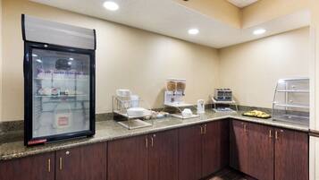 Una kitchenette equipada con refrigerador, cafetera, tostadora y microondas.