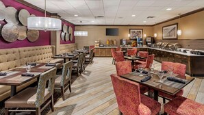 A restaurant with booths, tables, and a bar area.