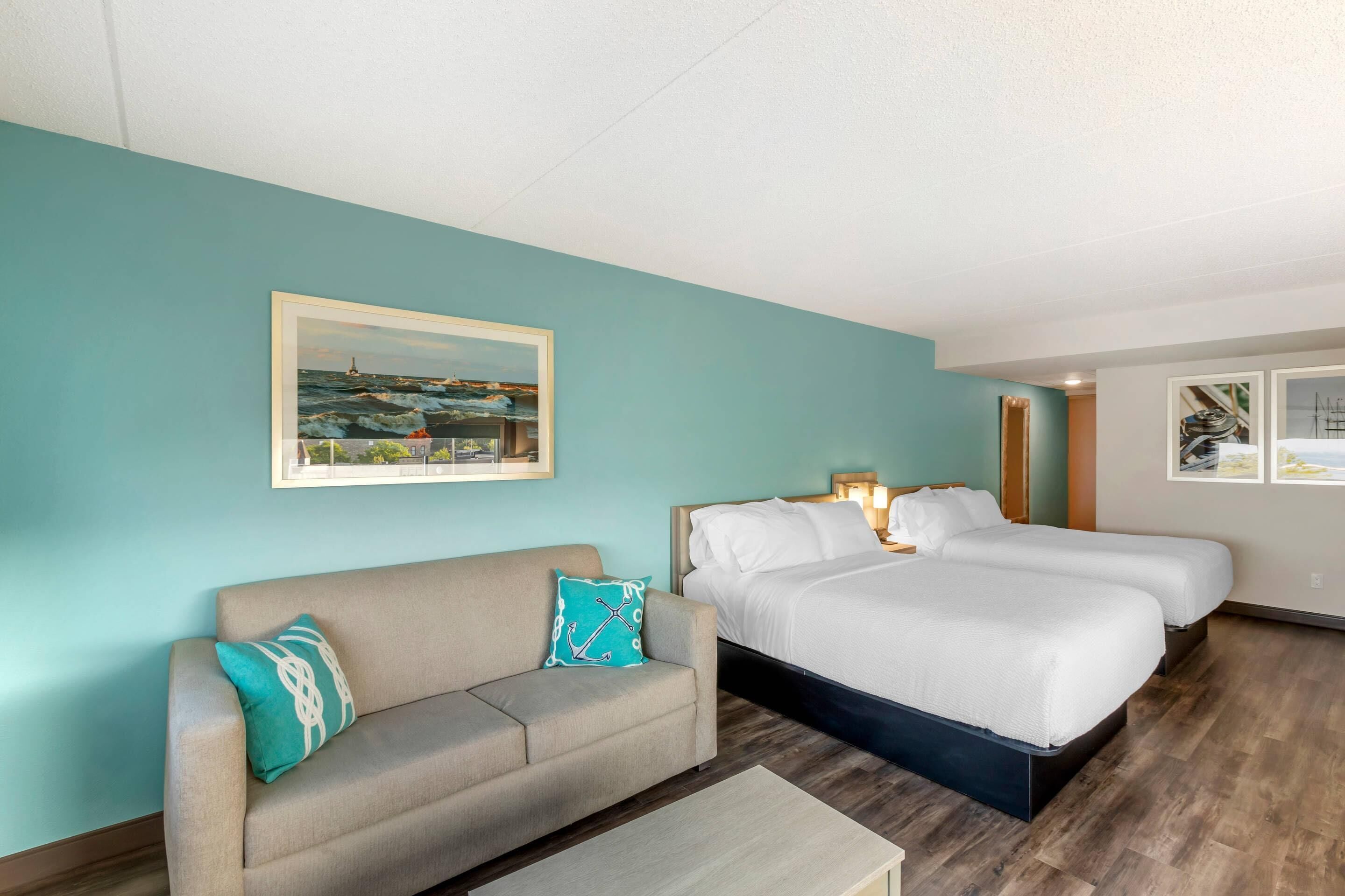 Une chambre d’hôtel avec un lit, un canapé et un tableau au mur.