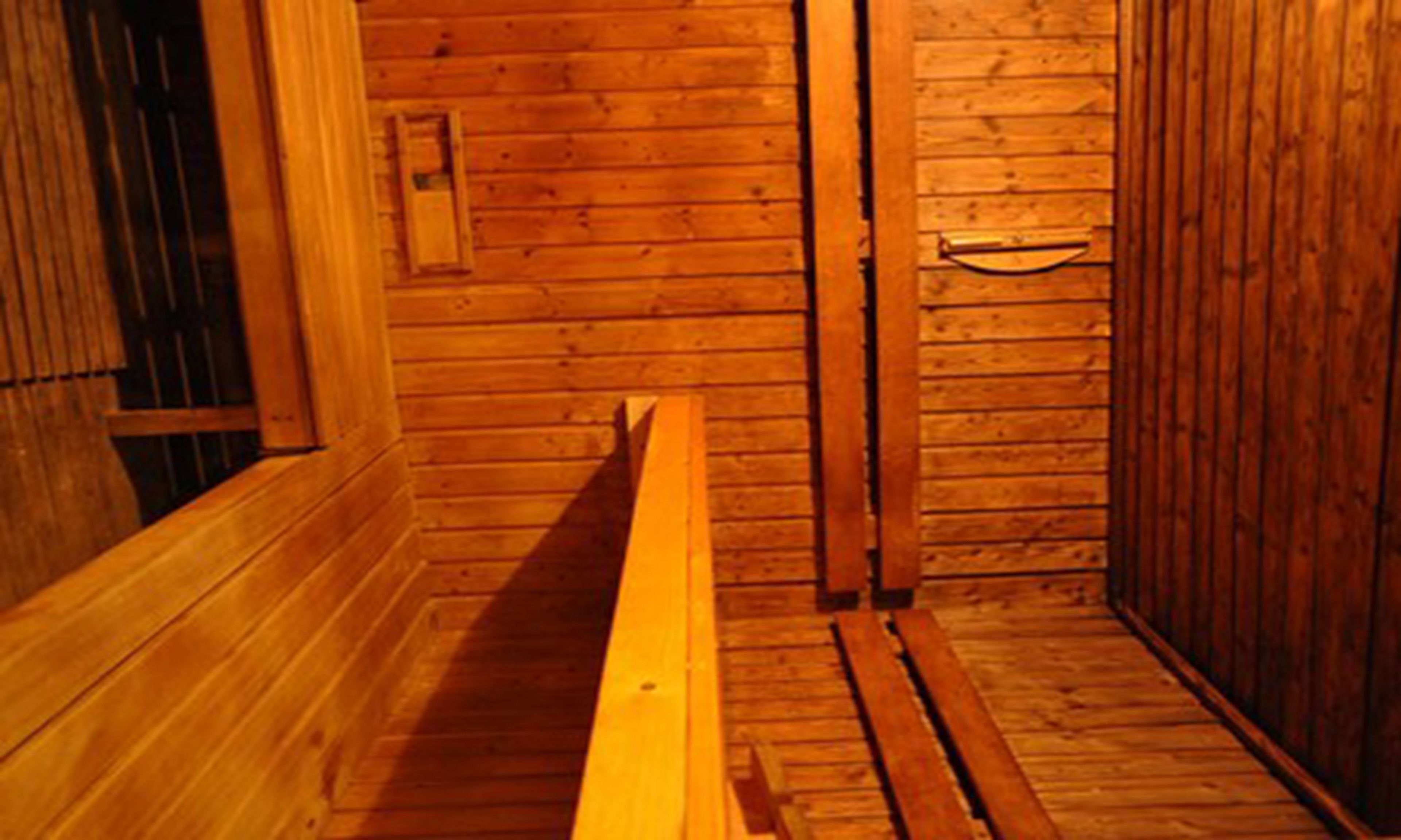 A wooden interior with a bench and a door.