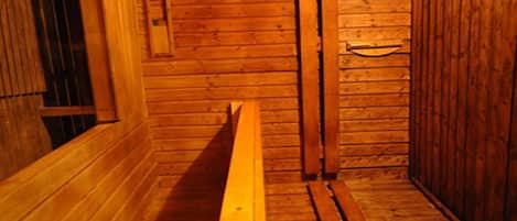 A wooden interior with a bench and a door.