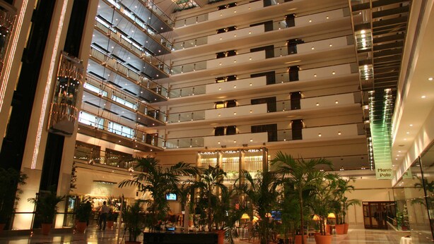 A multi-level atrium with glass railings, indoor plants, and a central open area with seating. - Pearl Continental Lahore (Lahore)