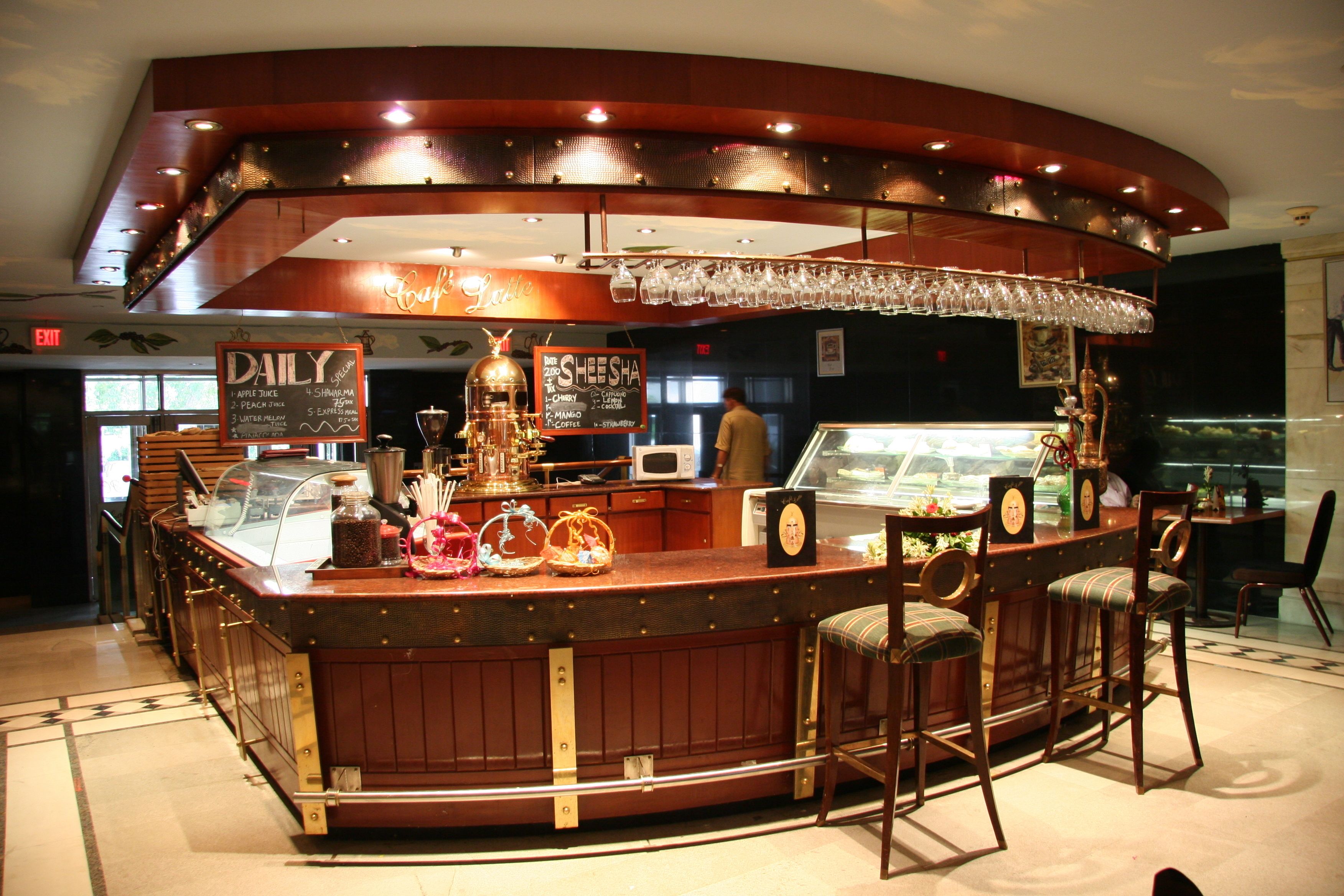 A bar area with a counter, stools, and a menu board.
