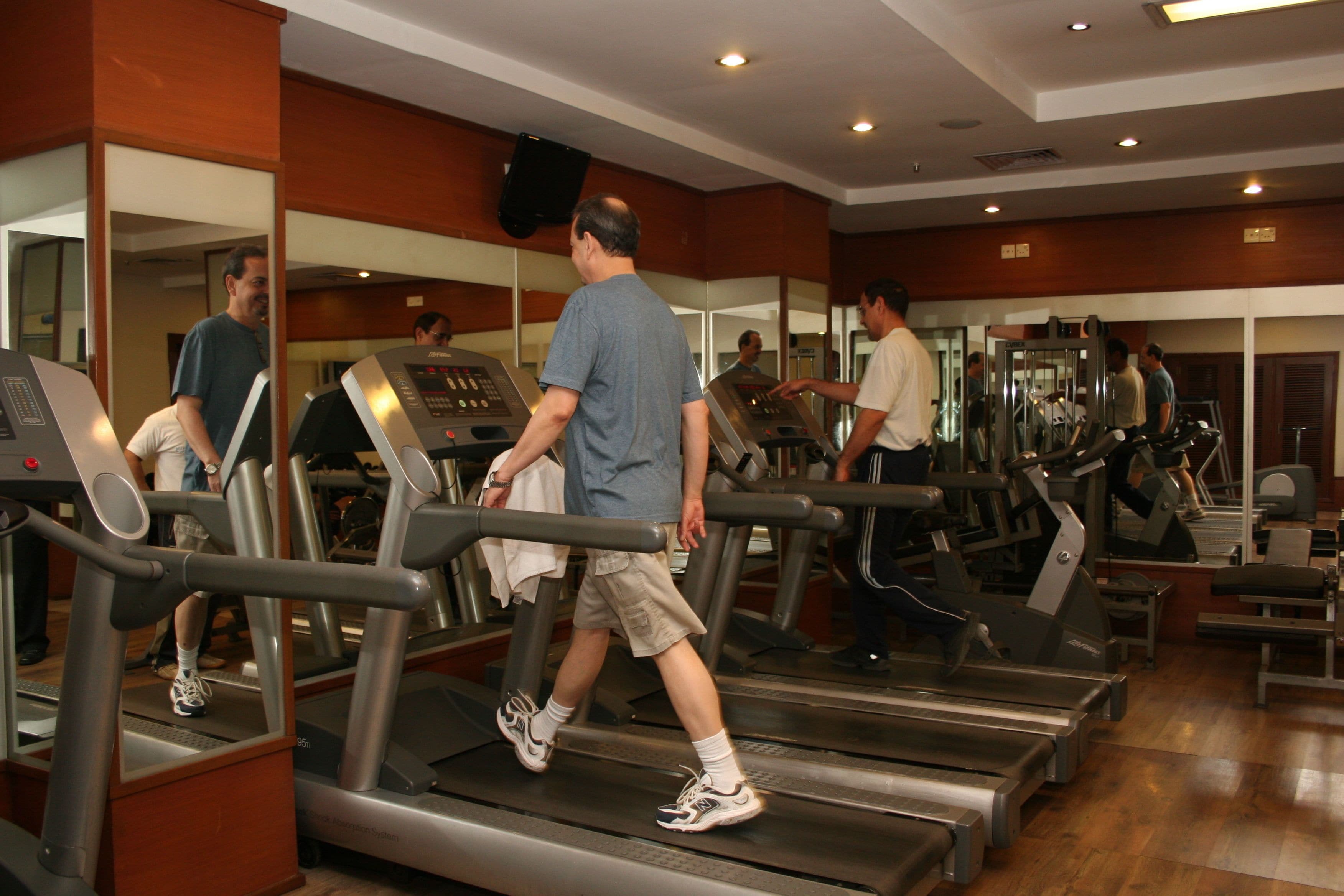 A gym with treadmills, weight machines, and mirrors.