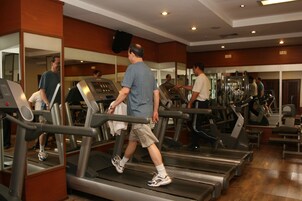 A gym with treadmills, weight machines, and mirrors.