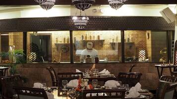 A restaurant interior with a bar area visible through a large window.
