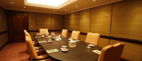 A conference room with a long table, chairs, and a floral centerpiece.