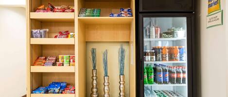 A kitchenette with shelves stocked with snacks, beverages, and packaged goods.