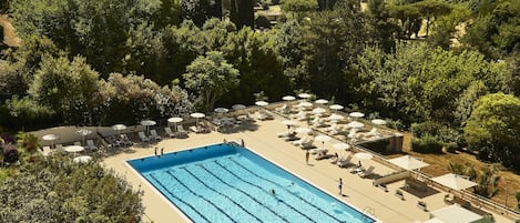 Una piscina al aire libre de temporada, sombrillas