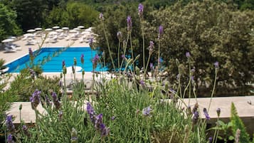 Zona de piscina amb gandules i vista a un paisatge forestal.