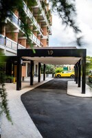Ingresso coperto di un edificio con un cartello 'VP', un'auto gialla parcheggiata all'interno e una bicicletta sullo sfondo.