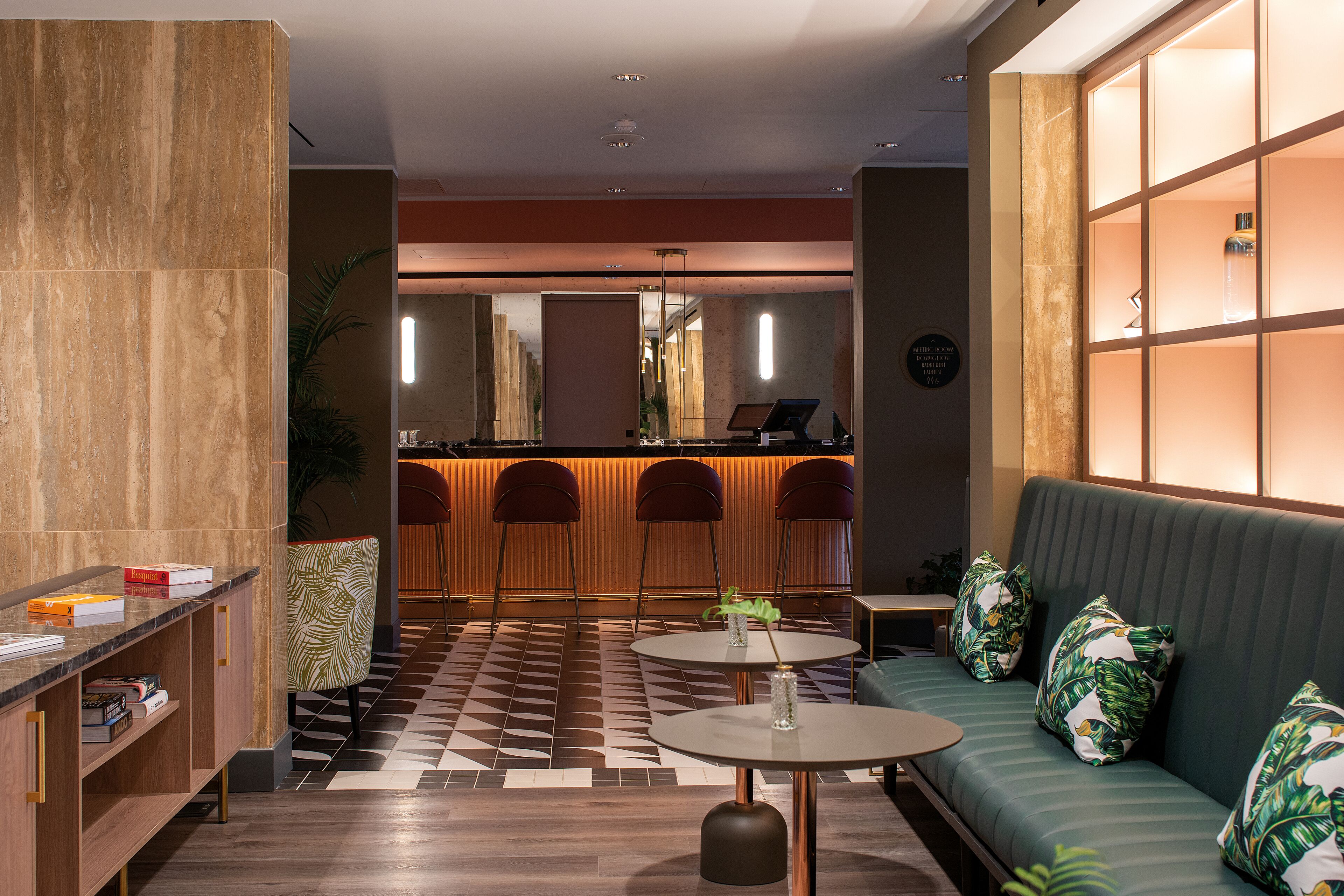 Un hall d’entrée moderne avec un comptoir d’accueil, un espace salon et un sol à motifs.