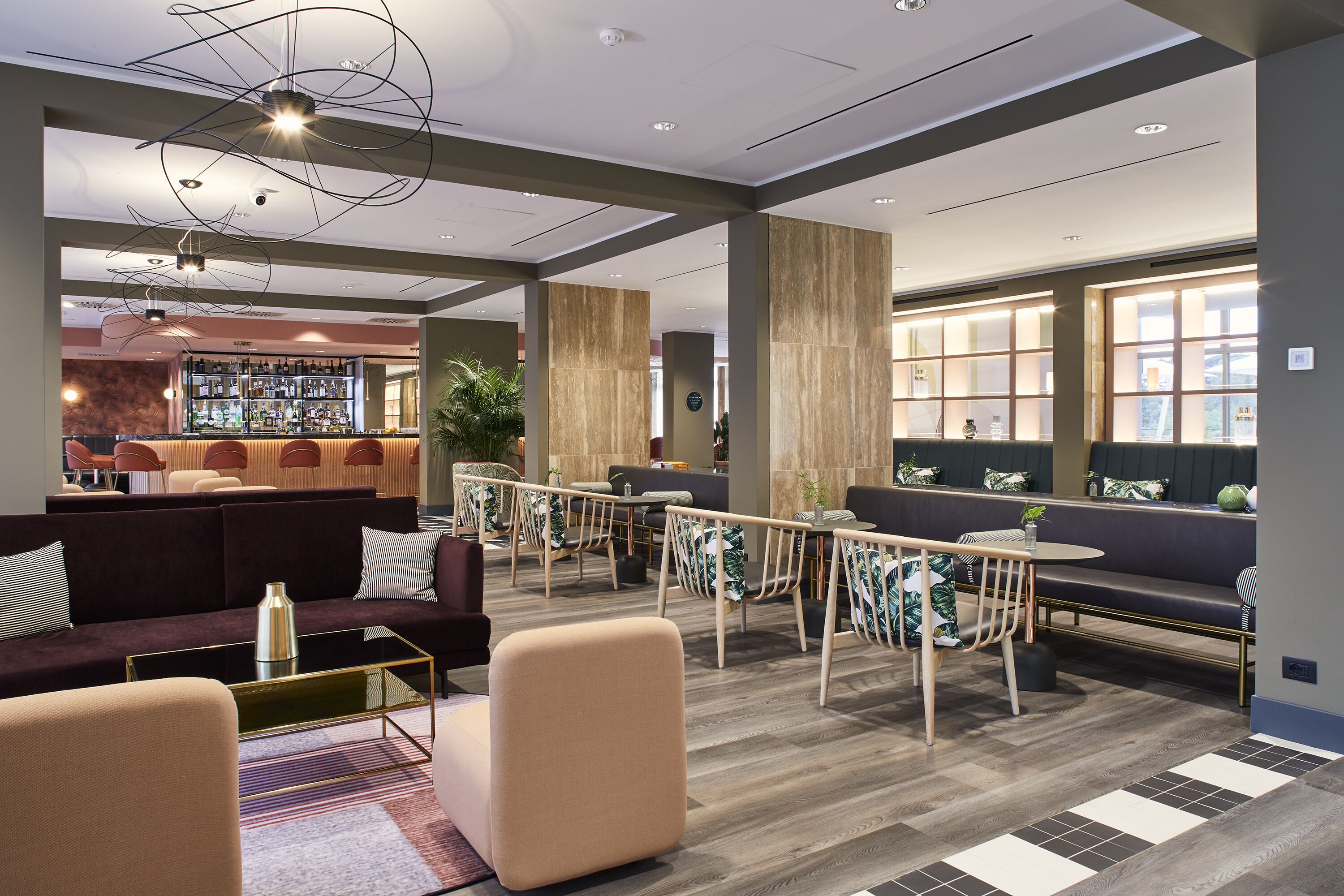 Um lobby moderno com áreas de estar, bar e balcão de recepção.