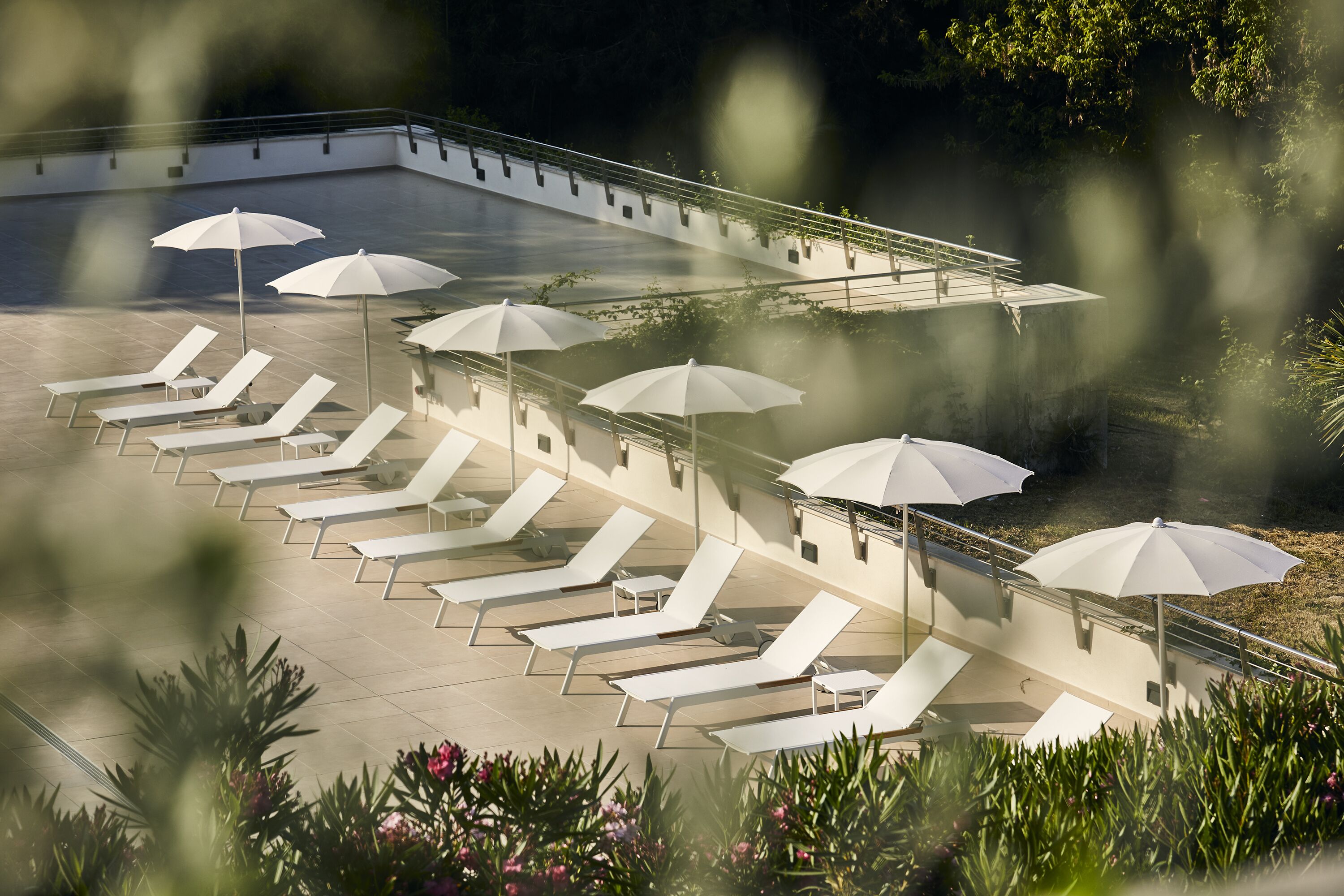 A poolside area with lounge chairs and umbrellas.
